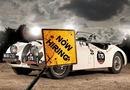 now hiring sign in front of a car